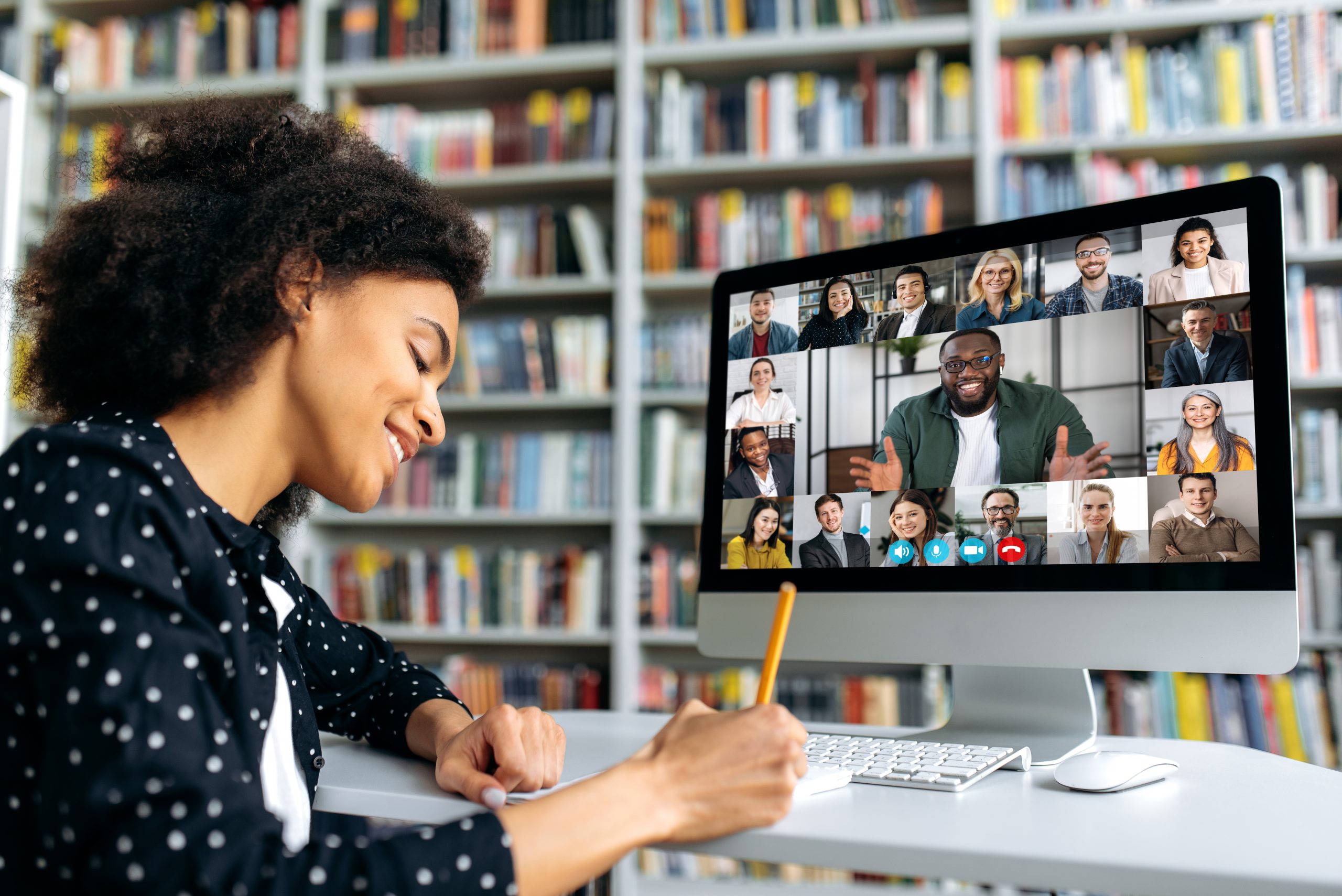 Video call, online education. African American happy female student, learning distantly, watches an online lecture, taking notes, multiracial smiling people on a computer screen, virtual communication Video call, online education. African American happy female student, learning distantly, watches an online lecture, taking notes, multiracial smiling people on a computer screen, virtual communication